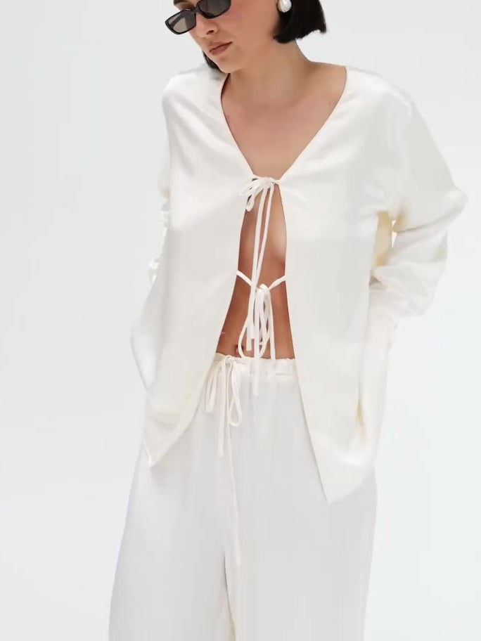 क्रीम रंग का सैटिन टाई-फ्रंट टॉप और वाइड-लेग पैंट का सेट